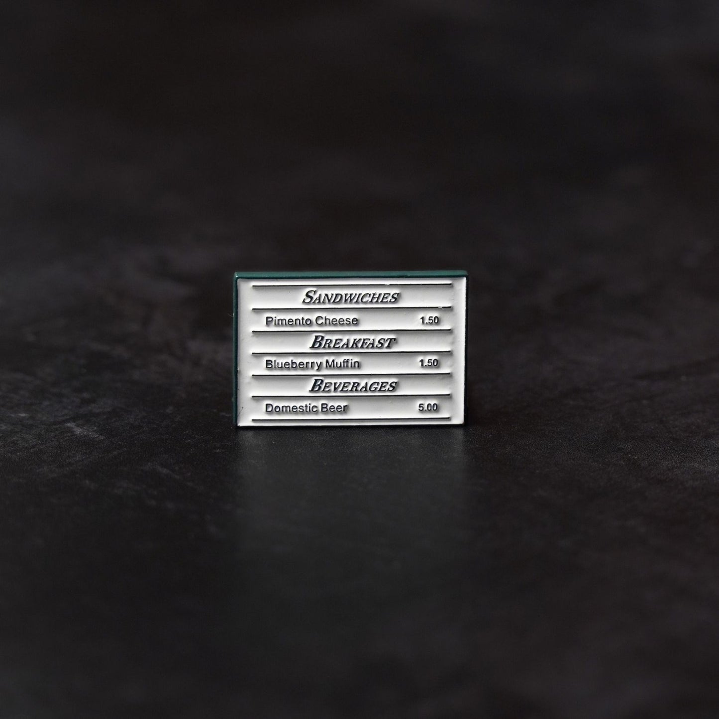 Metal golf ball marker on a dark textured surface