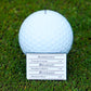 Golf ball marker with a menu card on grass