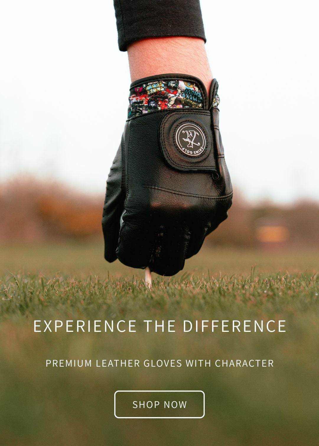 Hand wearing a black leather glove with floral pattern on the wrist, held above grass with text 'Experience the Difference' and 'Shop Now' button.