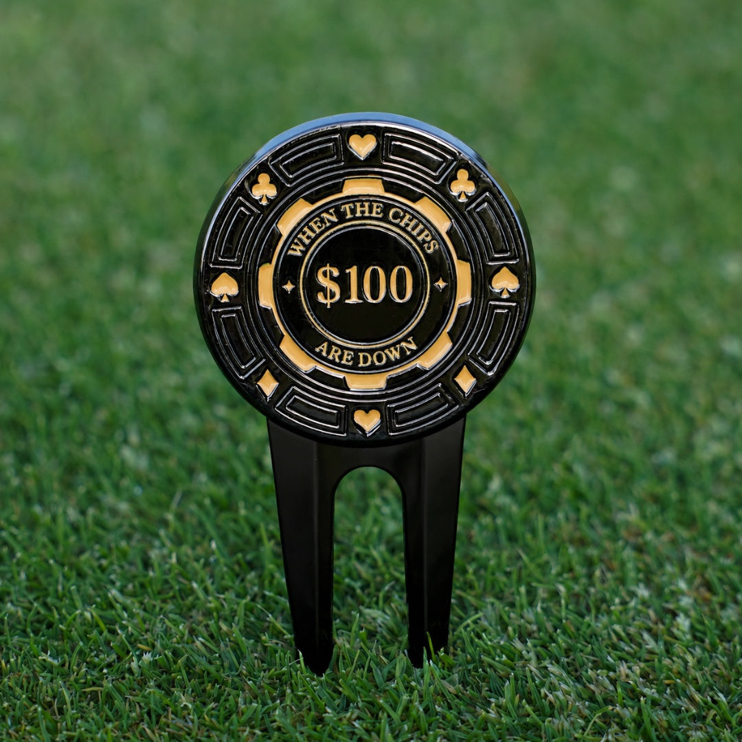 Golf divot tool with poker chip design and text on a grass background