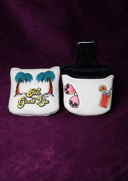 Two decorative mallet headcovers with palm trees and beach-themed designs on a purple background