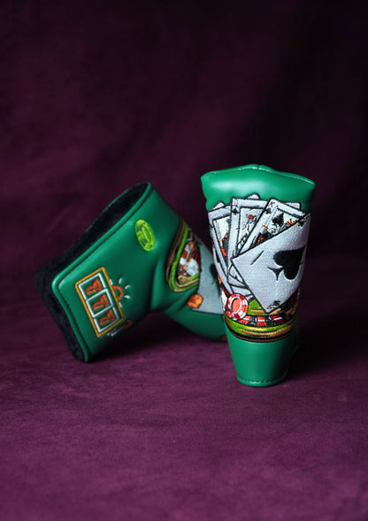 Two green golf club head covers with card and slot machine designs on a purple background