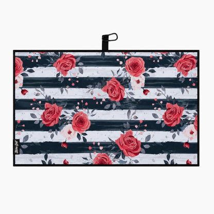 A golf towel with a black carrying strap, featuring a pattern of red and pink watercolor roses over horizontal black and white stripes, shown on a light gray background.
