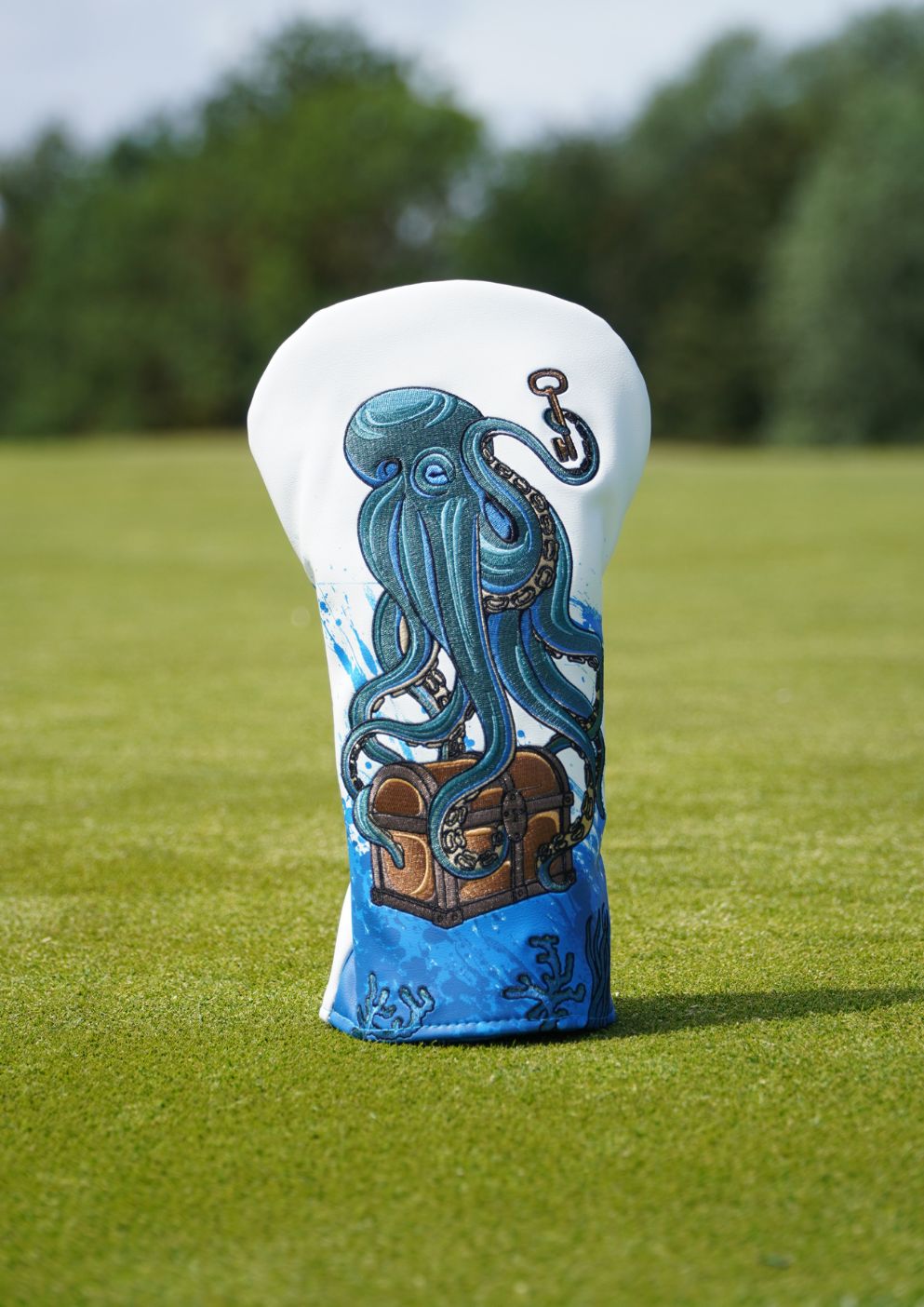 Golf club head cover with octopus design on a grassy background