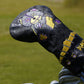 Golf club head cover with decorative patterns on a grass background